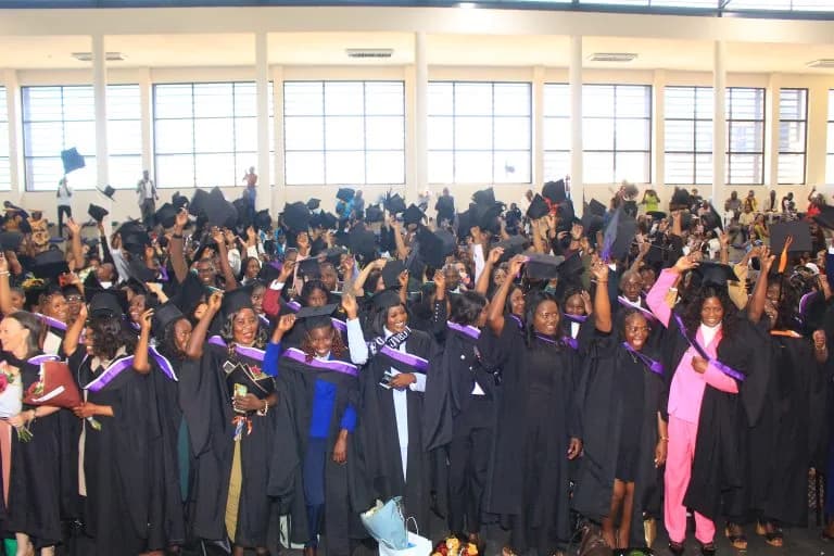 Graduates in gowns celebrating at a NAMCOL graduation ceremony
